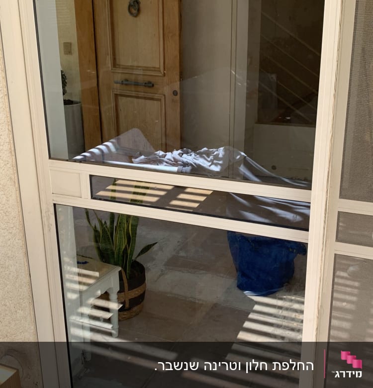 דלת זכוכית עם השתקפות אור וצל